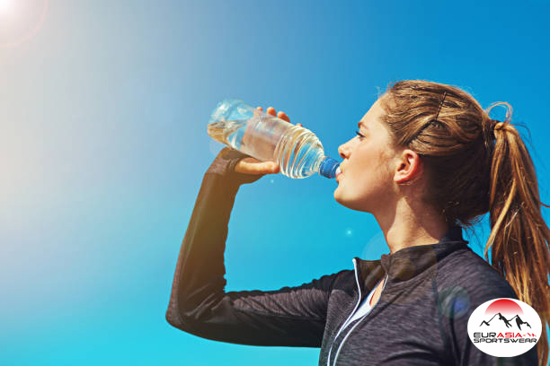 Shot of a sporty young woman drinking water outdoors